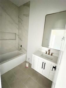 Bathroom with vanity, tiled shower / bath combo, and tile patterned floors