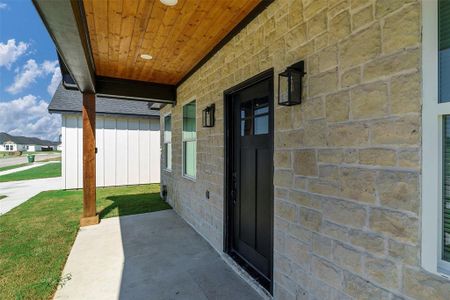 Entrance to property featuring a yard and covered porch