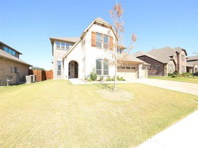 View of front of house with central AC, a front yard, and a garage