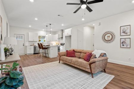 Living room with light hardwood / wood-style flooring and ceiling fan