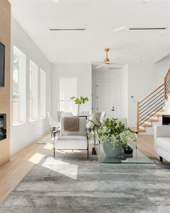 Living room featuring a healthy amount of sunlight, wood-type flooring, and ceiling fan