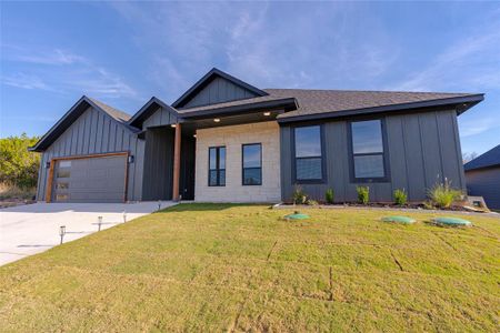 View of front of house with a garage and a front yard