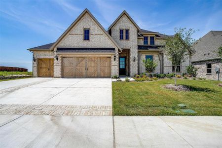 View of front of property featuring a front lawn and a garage