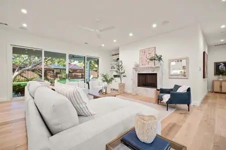 Living room with light hardwood / wood-style flooring, a premium fireplace, and a wealth of natural light