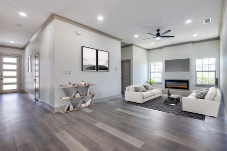 Living room with crown molding, ceiling fan, and dark hardwood / wood-style flooring