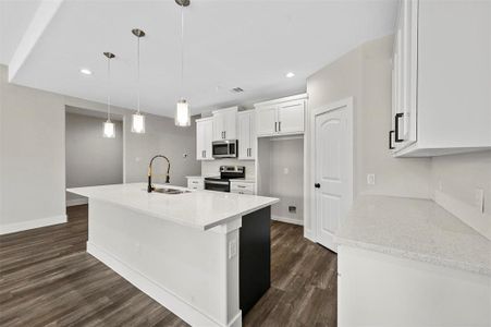 Kitchen featuring white cabinetry, decorative light fixtures, stainless steel appliances, sink, and dark hardwood / wood-style floors