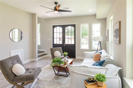 Living room featuring ceiling fan, french doors, and light wood-type flooring