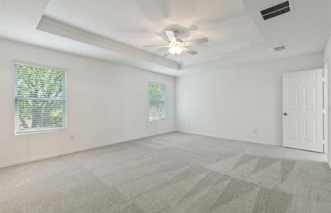 Elegant owner's suite with tray ceiling *real home pictured