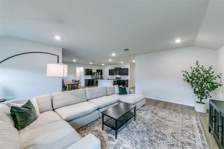 Living room with hardwood / wood-style flooring and vaulted ceiling