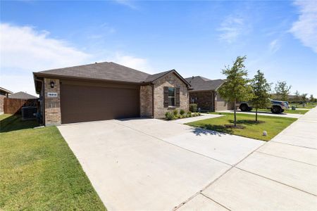 Ranch-style home featuring a garage, central air condition unit, and a front yard