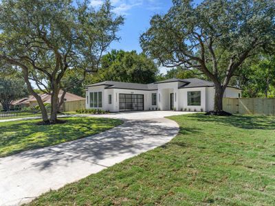 View of front facade featuring a garage and a front lawn