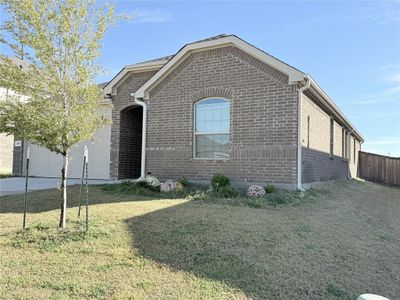 View of front facade featuring a garage and a front yard