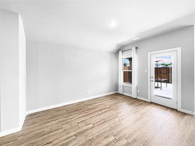 Kitchen with stainless steel appliances, sink, white cabinetry, hardwood / wood-style flooring, and a spacious island