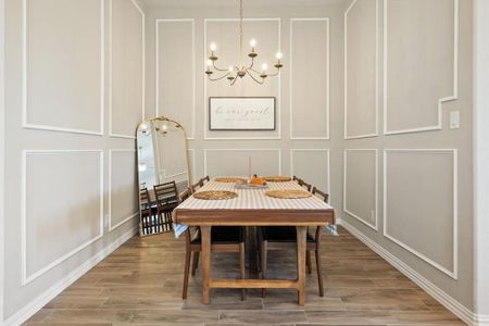 Dining area with gorgeous molding and a stunning matte gold chandelier