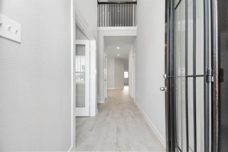 The majestic entryway allures with its high ceilings, embellished with sophisticated wood-look tile flooring and sleek oversized baseboards. Sample photo of completed home with similar floor plan. Actual colors and selections may vary.