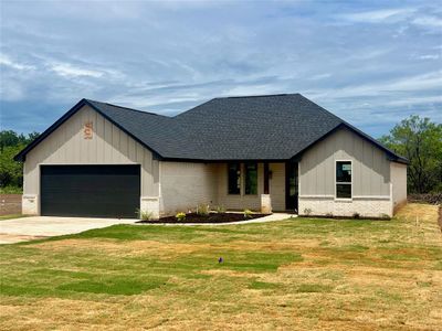 Modern farmhouse with a garage and a front lawn