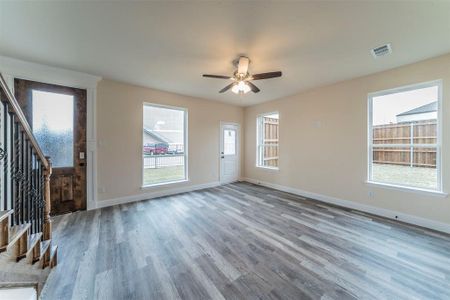 Unfurnished living room with ceiling fan and hardwood / wood-style flooring