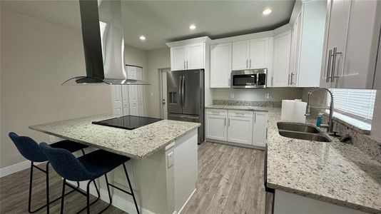 Kitchen w/ granite countertops, breakfast bar, built in cooktop, stainless steel appliances and pantry