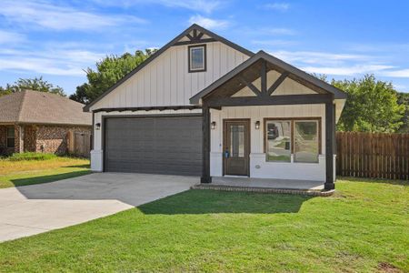 View of front of property featuring a garage and a front lawn