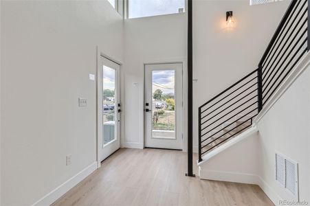 Multilevel atrium entryway flooded with natural light.