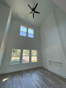 Bonus room with hardwood / wood-style floors, ceiling fan, and high vaulted ceiling