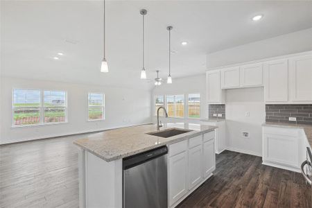 Kitchen with dishwasher, a wealth of natural light, sink, and white cabinetry