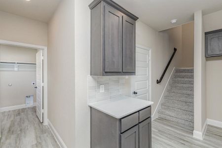 Kitchen with light wood-type flooring and tasteful backsplash