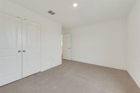 Unfurnished bedroom with light carpet and a closet