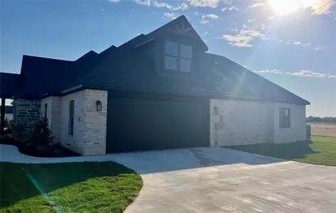 View of home's exterior featuring a garage and a yard