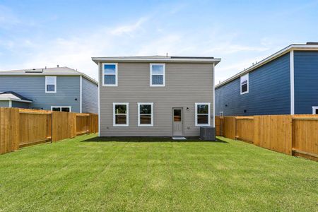 Back of property with central AC and a lawn