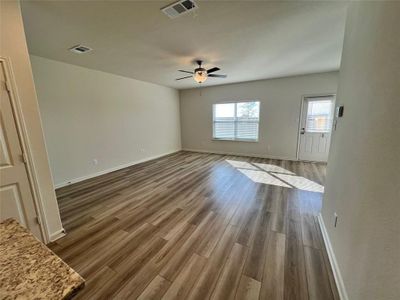 Living room/dining featuring ceiling fan and vinyl flooring