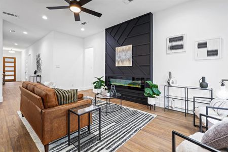 Living room with ceiling fan, a fireplace, and hardwood / wood-style floors