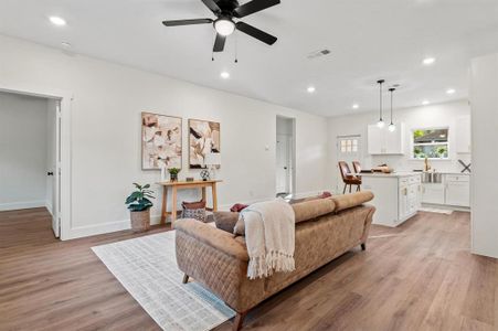 Living room with light hardwood / wood-style flooring, sink, and ceiling fan