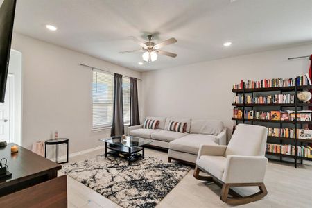 Living room with light wood-type flooring and ceiling fan