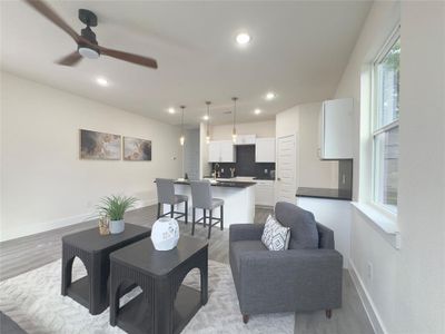 Living room featuring ceiling fan, sink, and wood-type flooring