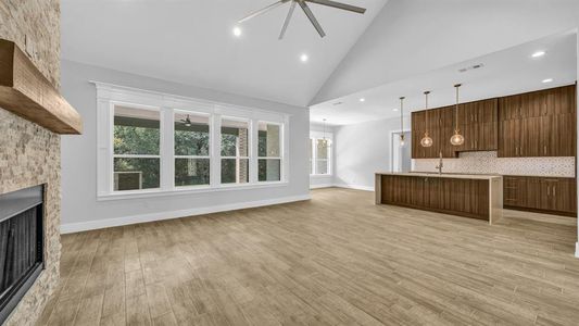 Kitchen with a kitchen island with sink, sink, stainless steel appliances, and decorative light fixtures