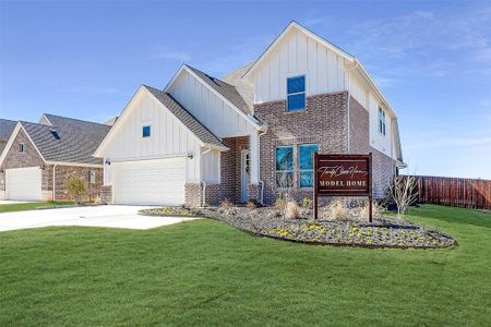 View of front of house featuring a front lawn and a garage