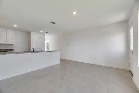 Unfurnished living room featuring sink and light tile patterned floors