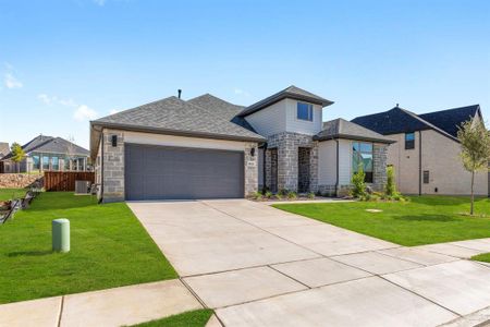 View of front of home with a front lawn, central air condition unit, and a garage