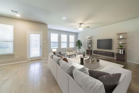 Living room with ceiling fan and light hardwood / wood-style floors