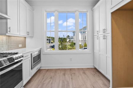 Kitchen with white cabinets, stainless steel appliances,and a healthy amount of sunlight
Pictures represent a previously built home