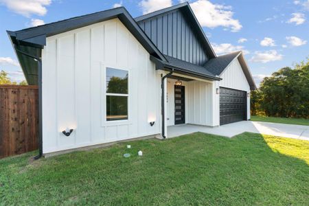 Modern farmhouse style home featuring a front yard and a garage