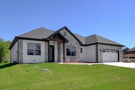 View of front of property featuring a garage and a front lawn