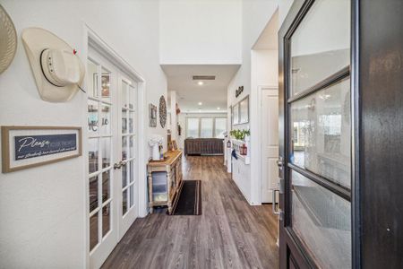 Bright and welcoming entryway with abundant natural light flowing through the open first-floor plan. To the left, a versatile home office/study provides the perfect space for work or relaxation.