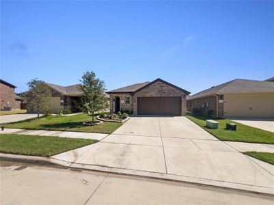 Ranch-style house with a garage and a front lawn