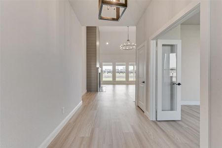 Hall featuring a chandelier and light hardwood / wood-style floors