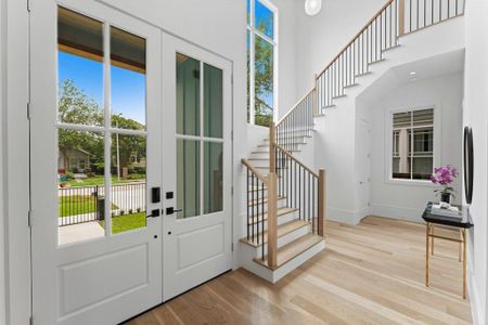 The foyer features a soaring two story entry way and white oak hardwood stairs along with beautiful views of the tree lined street.