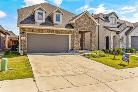 View of front facade featuring a garage and a front lawn