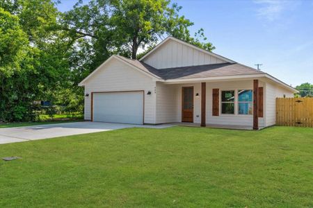 View of front of property featuring a garage and a front lawn