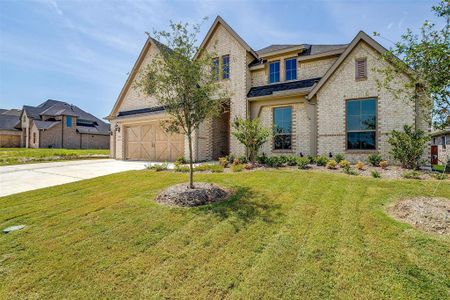 View of front of property featuring a front lawn and a garage